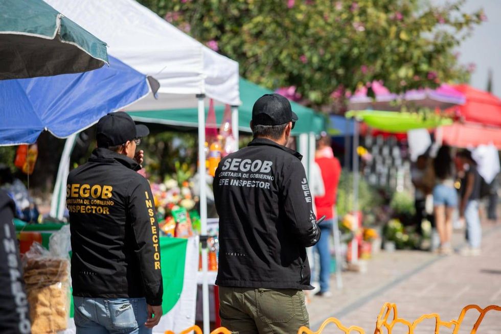 Agente camina entre peatones y puestos en San Juan del R\u00edo durante el operativo de D\u00eda de Muertos