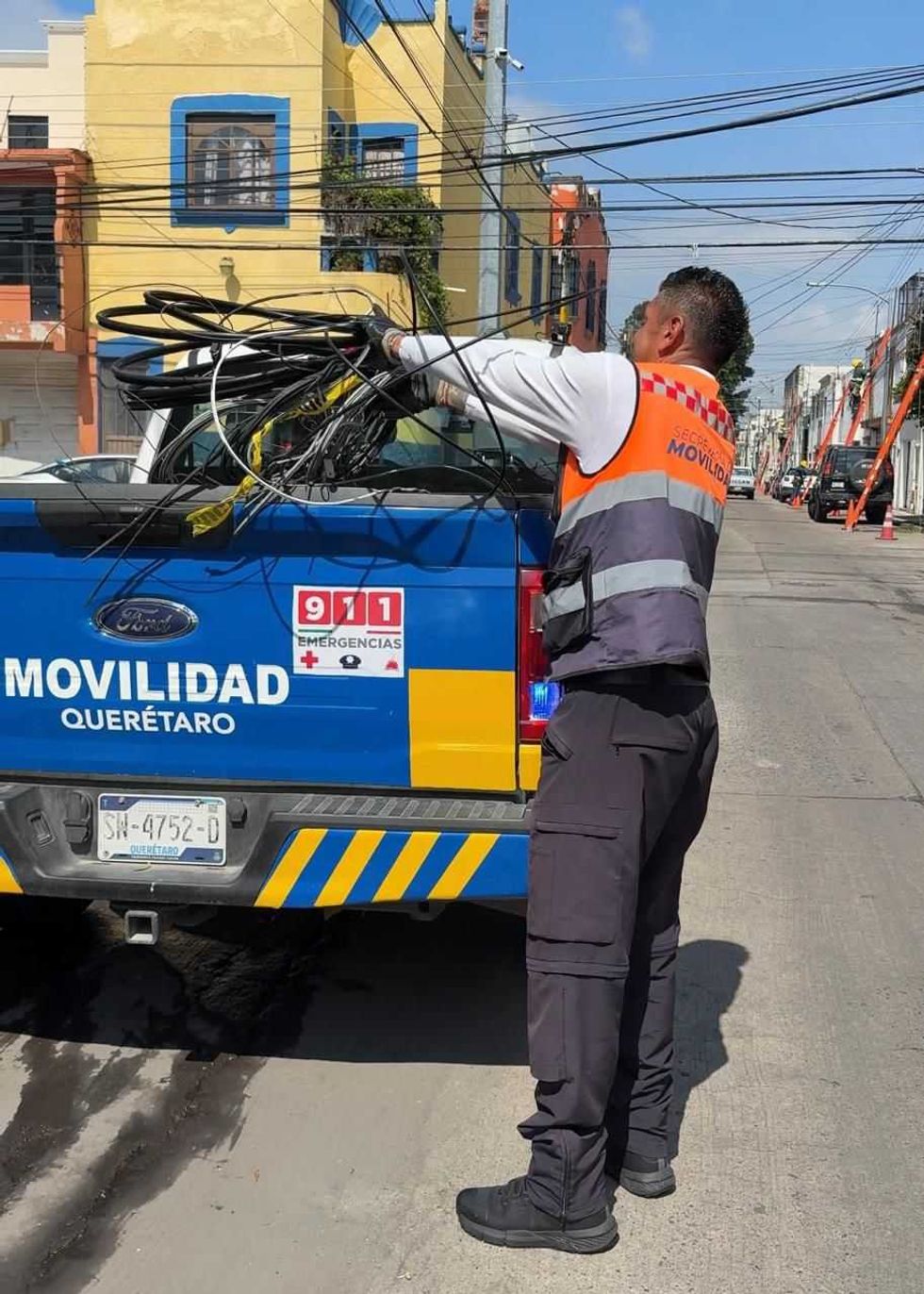 Agente de la Secretar\u00eda de Movilidad de Quer\u00e9taro carga cables retirados en camioneta institucional durante operativo