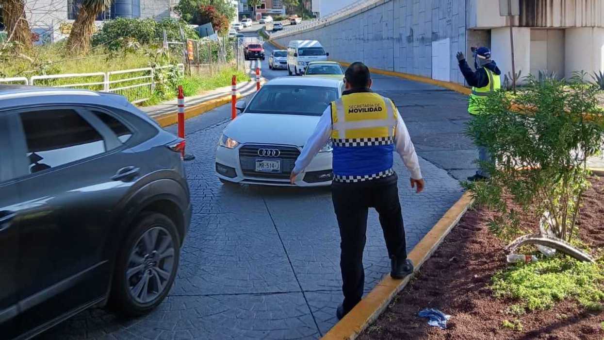 Agente de la Secretar\u00eda de Movilidad dirige el tr\u00e1fico vehicular en Prolongaci\u00f3n Constituyentes, Quer\u00e9taro, ante la saturaci\u00f3n por obras en la autopista M\u00e9xico-Quer\u00e9taro.