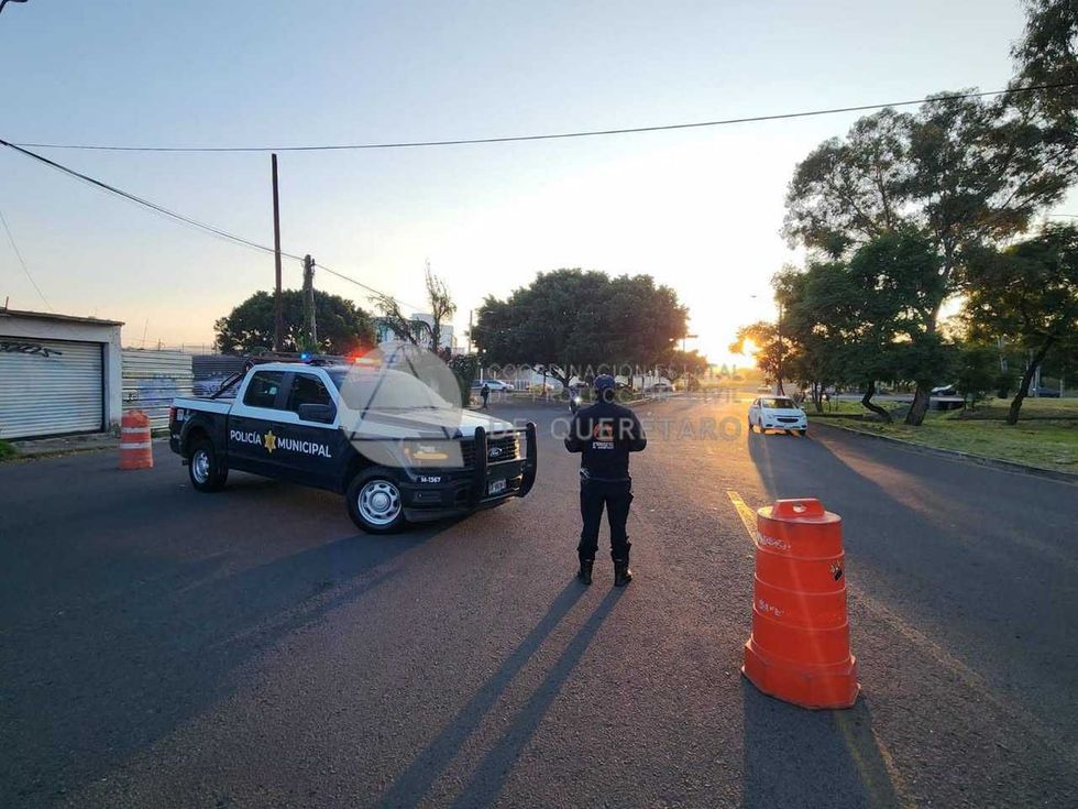 Agente de Protecci\u00f3n Civil y patrulla municipal resguardan un cruce cerca de la zona de la volcadura sobre la carretera federal 57 en Quer\u00e9taro
