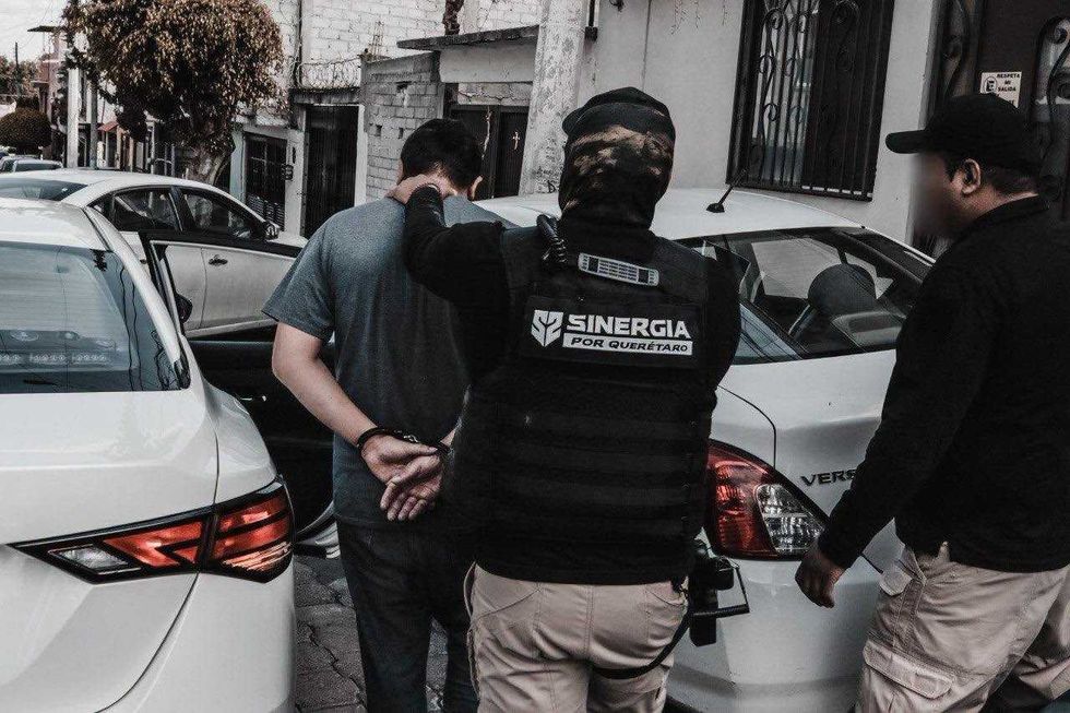 Agente de Sinergia por Quer\u00e9taro traslada a una persona detenida durante operativo contra delitos contra la salud.