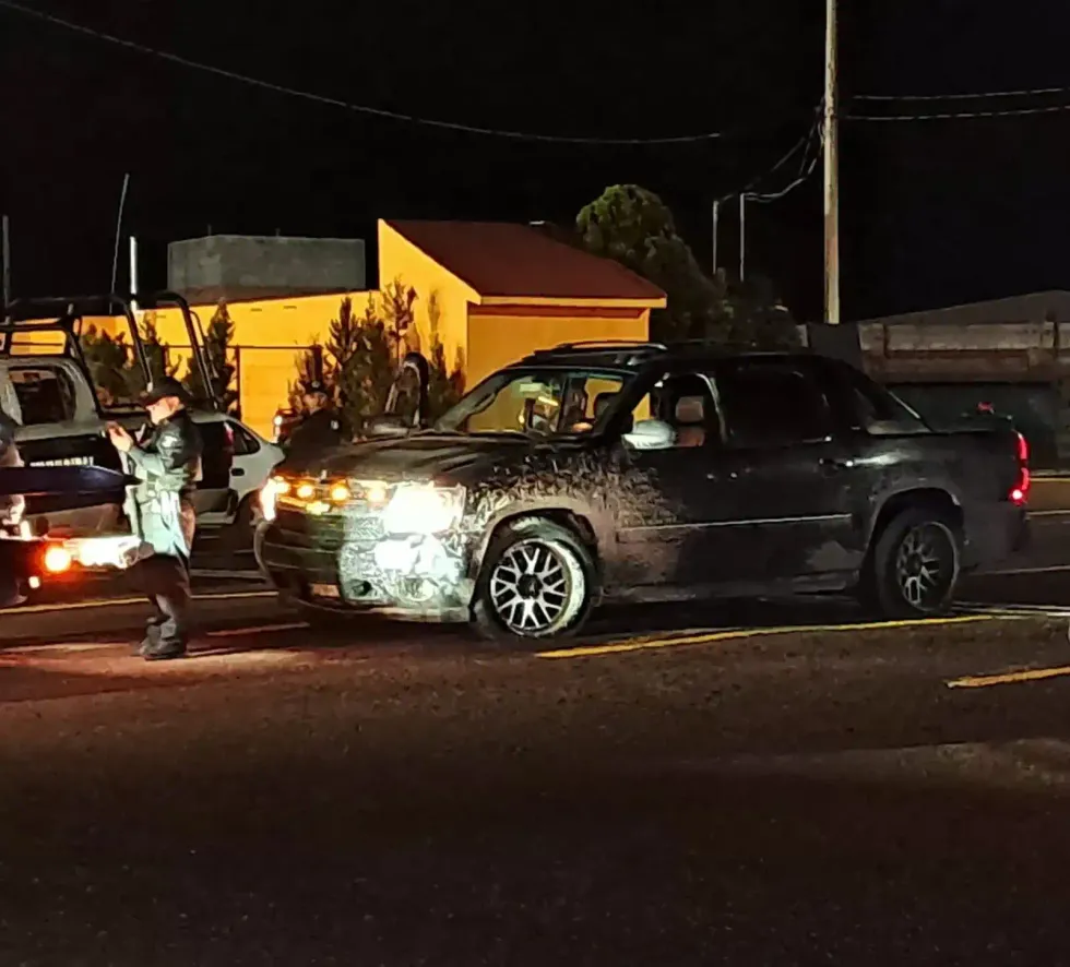 Agente junto a la camioneta Avalanche con luces encendidas y el frente da\u00f1ado