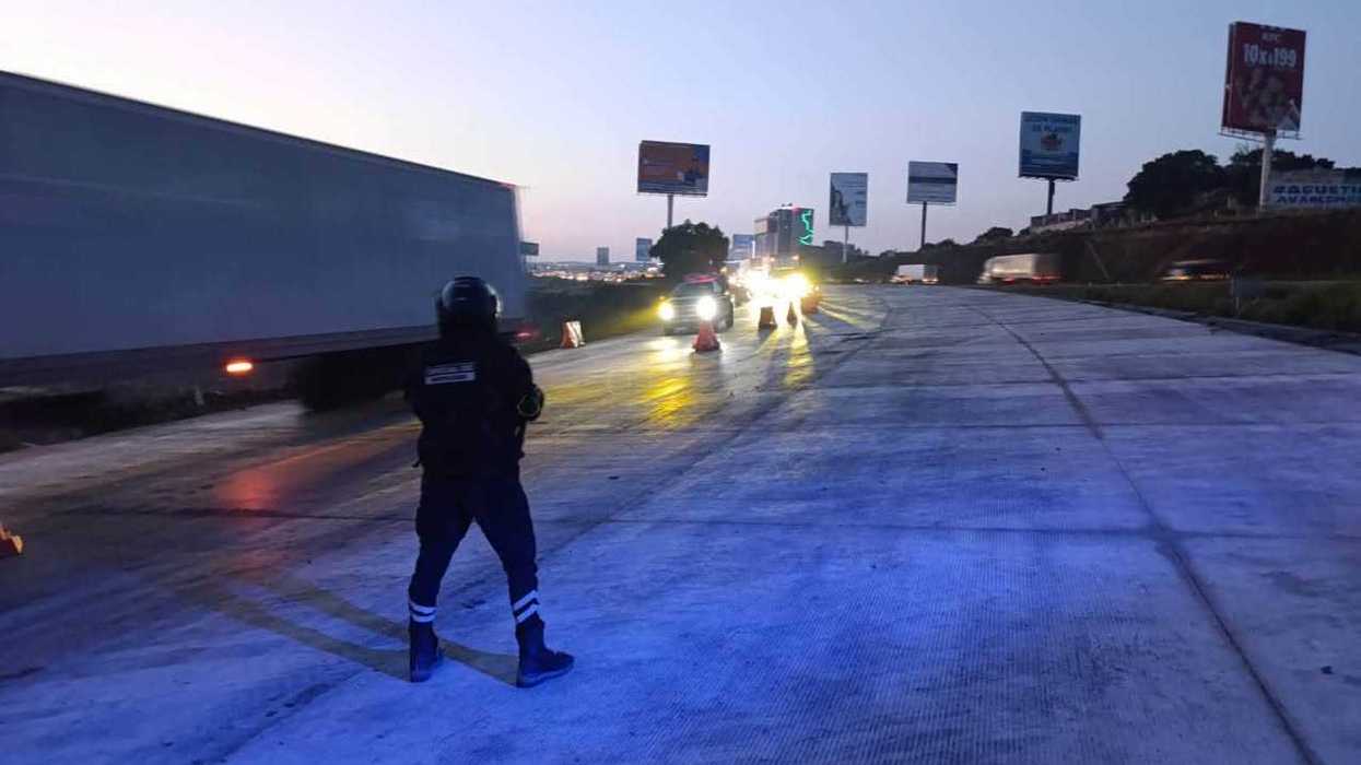 Agente vial dirige el tráfico en un carril de la México-Querétaro por obra en El Marqués
