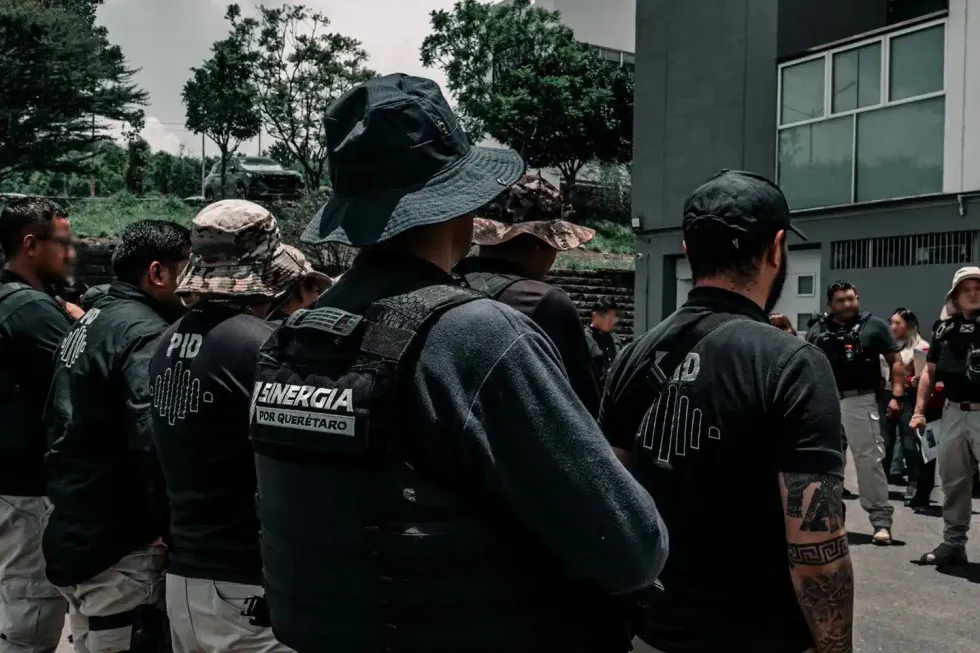Agentes con chalecos de la PID y Sinergia frente a un inmueble intervenido durante los cateos en Quer\u00e9taro
