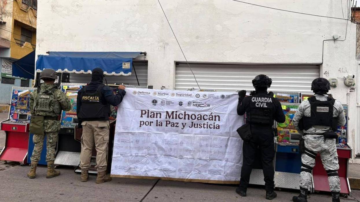 Agentes del Ejército, la Fiscalía, la Guardia Civil y la Guardia Nacional frente a una lona del Plan Michoacán