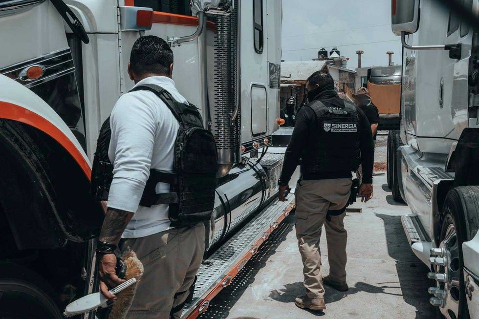 Agentes del operativo Sinergia realizan diligencias entre tractocamiones durante cateos en el municipio de Quer\u00e9taro.