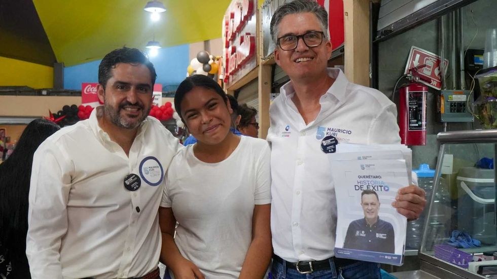 Agust\u00edn Dorantes L\u00e1mbarri y un funcionario estatal entregan volantes del Quinto Informe de Gobierno a comerciantes del mercado del Tepetate en Quer\u00e9taro.