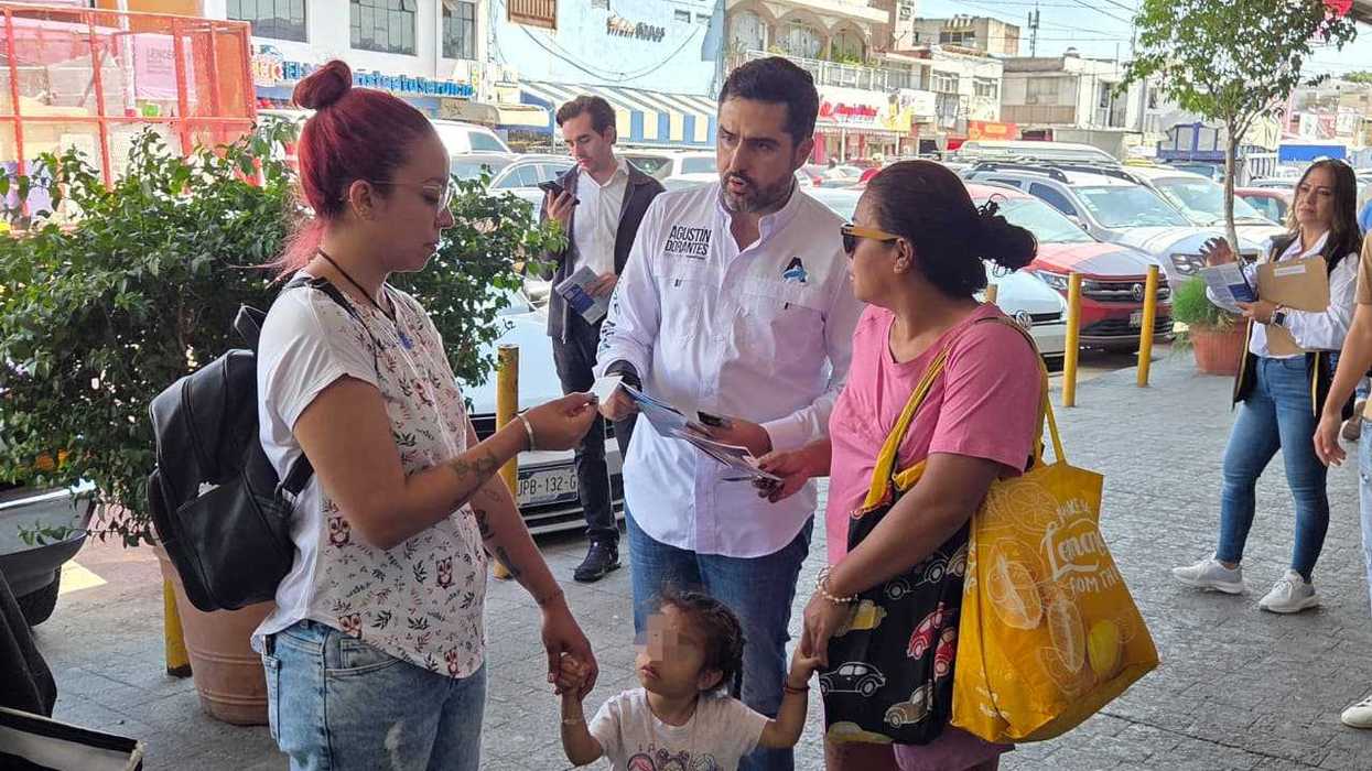 Agustín Dorantes Lámbarri entrega material informativo a ciudadanas en un espacio exterior durante su recorrido de Segundo Informe Legislativo en Querétaro, 2026
