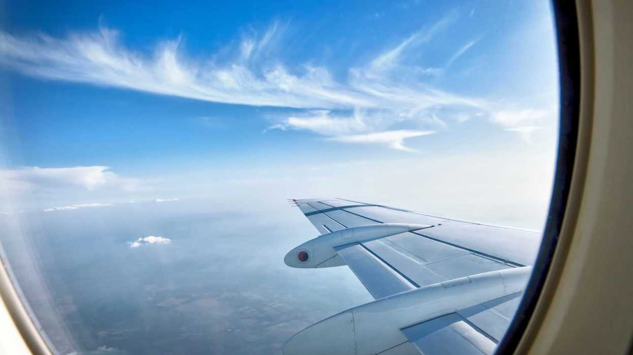 Ala de un avión vista desde la ventanilla en pleno vuelo con cielo azul y nubes; vuelo directo Querétaro-Madrid