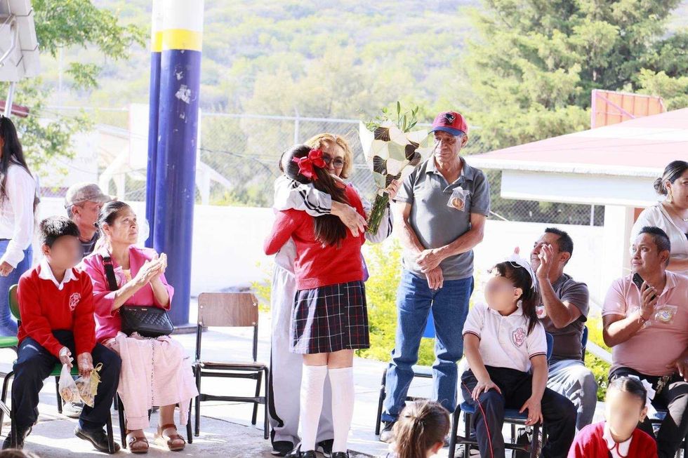 Alumna de primaria entrega flores a adulta mayor durante acto del programa "Botsu Muntsi" del DIF Quer\u00e9taro