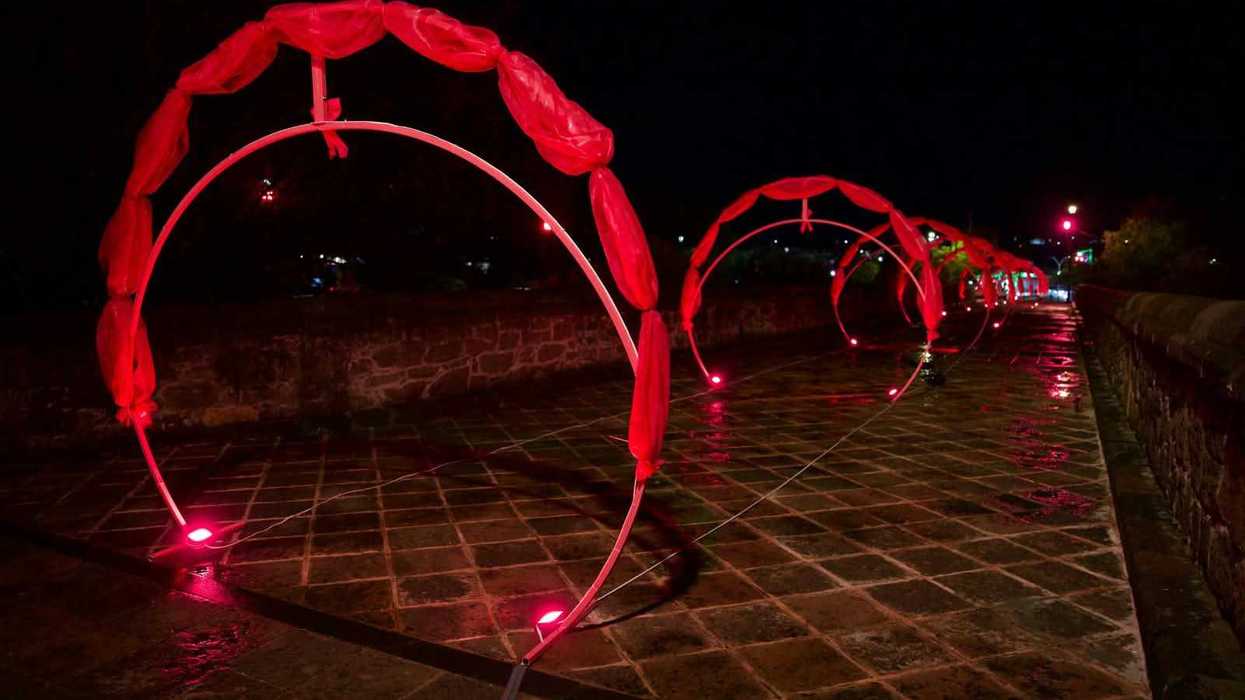 Arcos iluminados en perspectiva sobre el Puente de la Historia de San Juan del Río por el cáncer de mama