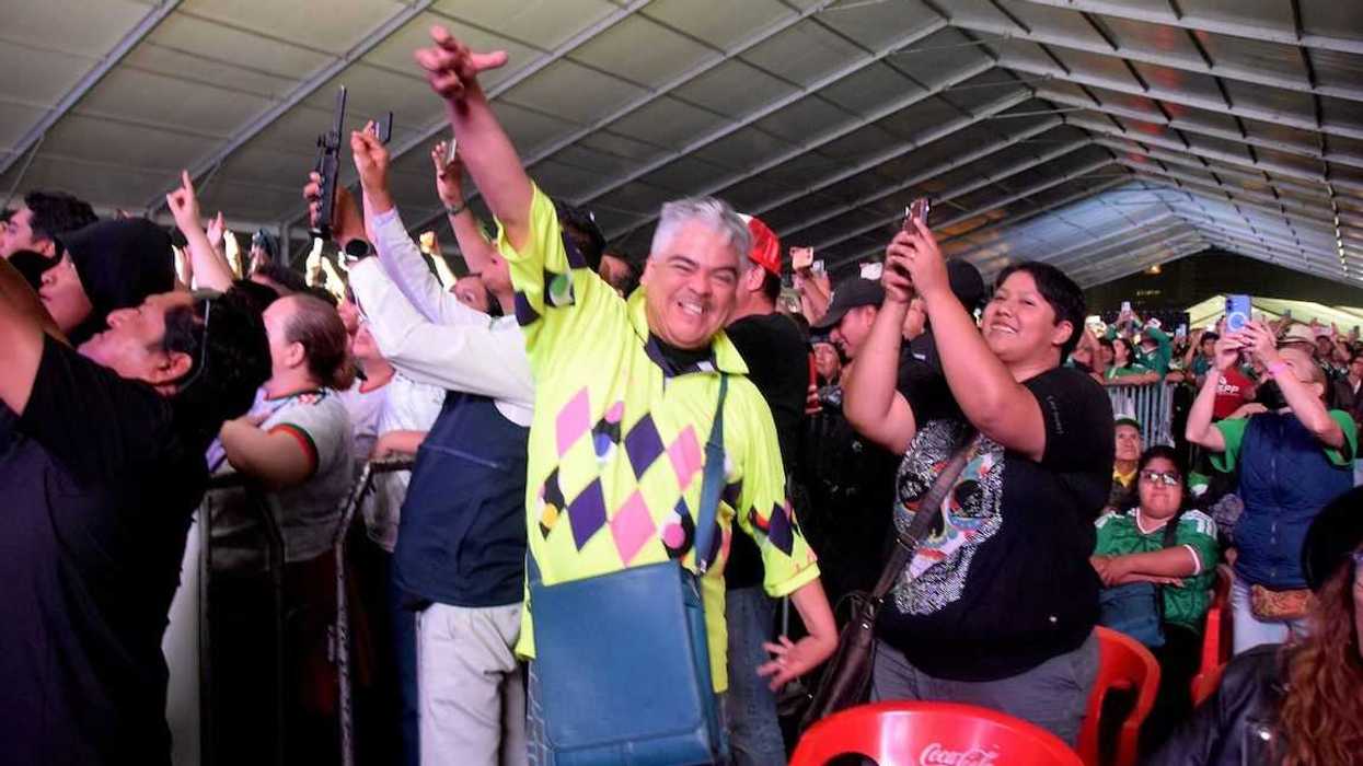 Asistente con camisa fluorescente baila entre el público durante un concierto en MéxicQ Fest.