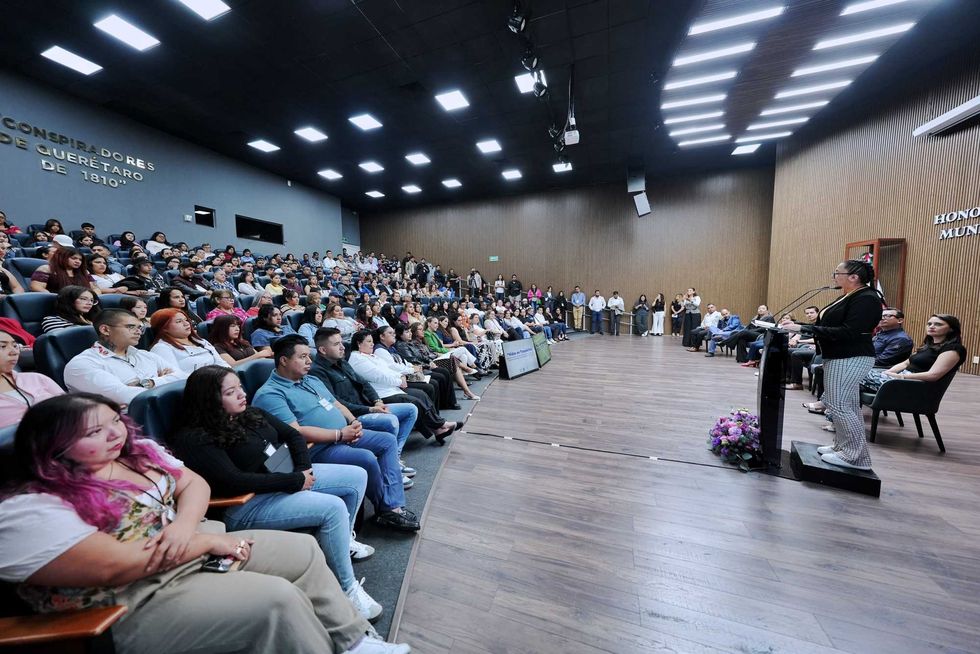 Asistentes al foro Vidas en Transici\u00f3n en el sal\u00f3n del Honorable Ayuntamiento de Quer\u00e9taro, con pantalla al fondo