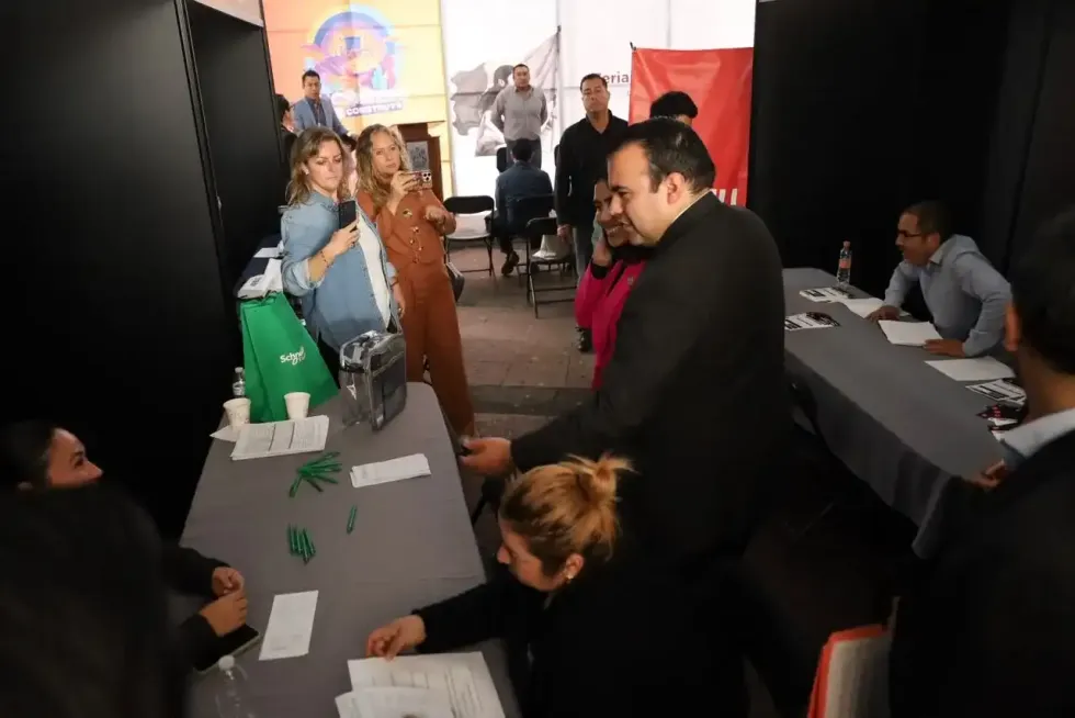 Asistentes atienden m\u00f3dulos de empresas y entregan documentos durante la Feria de Empleo Col\u00f3n 2026