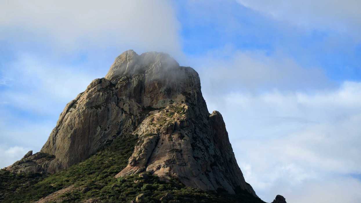 Asistentes con vestimenta blanca frente a la Peña de Bernal durante el equinoccio de primavera en Querétaro, con el monolito al fondo bajo cielo despejado.