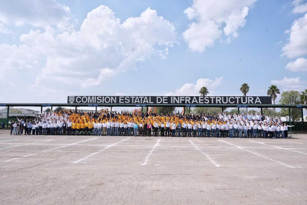 Asistentes de pie ante un fondo del Poder Ejecutivo del Estado de Quer\u00e9taro en el festejo del D\u00eda del Caminero