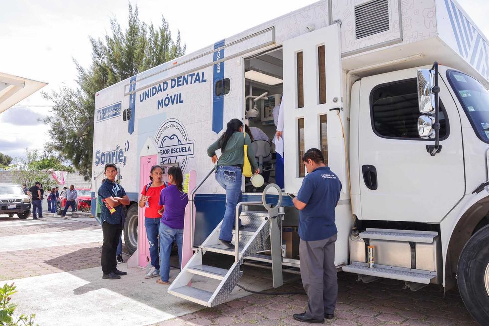 Asistentes hacen fila para subir a la Unidad Dental M\u00f3vil de la Universidad Cuauht\u00e9moc, estacionada en El Jaral durante la jornada de salud.