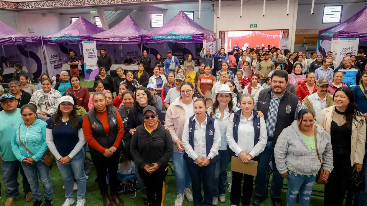 Asistentes y autoridades posan durante la jornada Aquí Contigo Mujeres en un espacio techado de San Joaquín