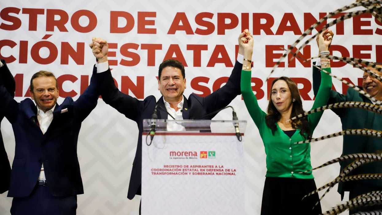 Astudillo Suárez levanta los brazos en el podio durante su registro ante la alianza Morena-PT-Verde en la Ciudad de México