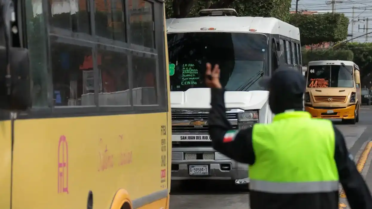 Autobús urbano detenido junto a una parada techada con usuarios en una avenida de San Juan del Río