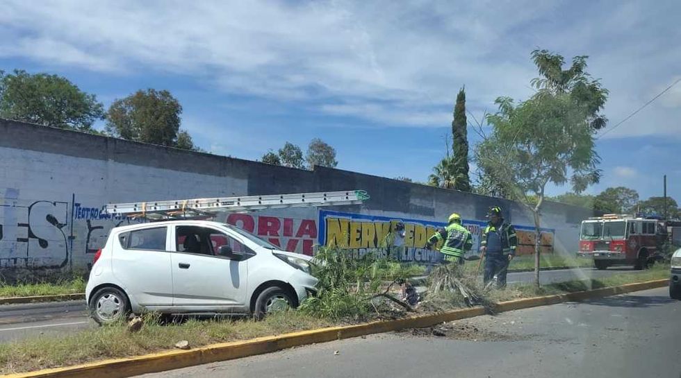 Autom\u00f3vil accidentado sobre el camell\u00f3n en San Juan del R\u00edo, con personal de emergencia y una unidad de bomberos en el lugar.