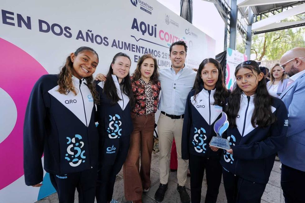 Autoridades de Quer\u00e9taro posan junto a deportistas que sostienen reconocimientos por sus resultados deportivos.
