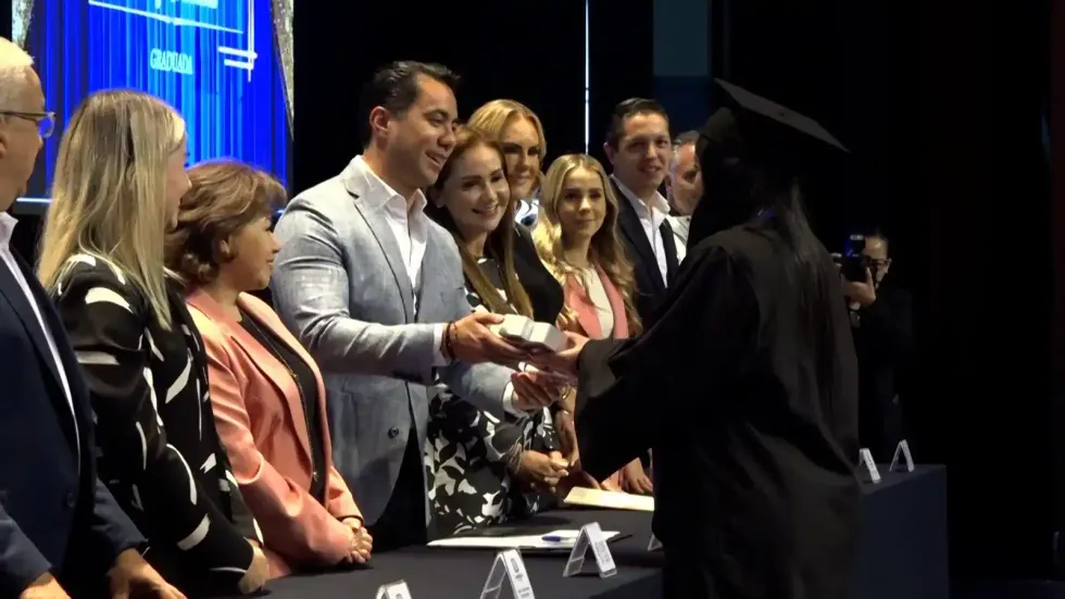 Autoridades entregan diploma a una egresada de la Universidad de las Mujeres