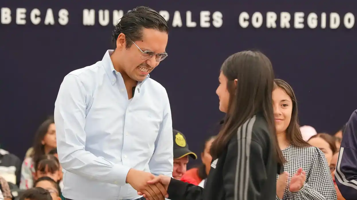 Autoridades municipales de Corregidora saludan a beneficiario en el acto de Becas A Paso Firme 2026