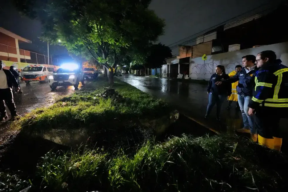 Autoridades municipales observan un canal pluvial durante la supervisi\u00f3n nocturna bajo la lluvia