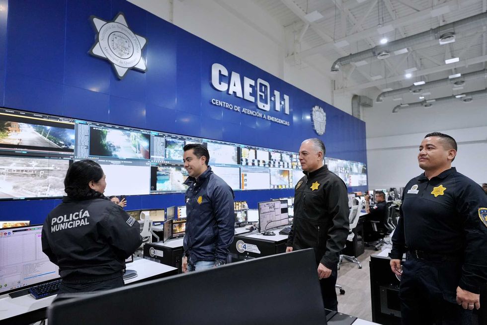 Autoridades municipales recorren el centro de monitoreo del CAE 911, con el letrero del centro al fondo.