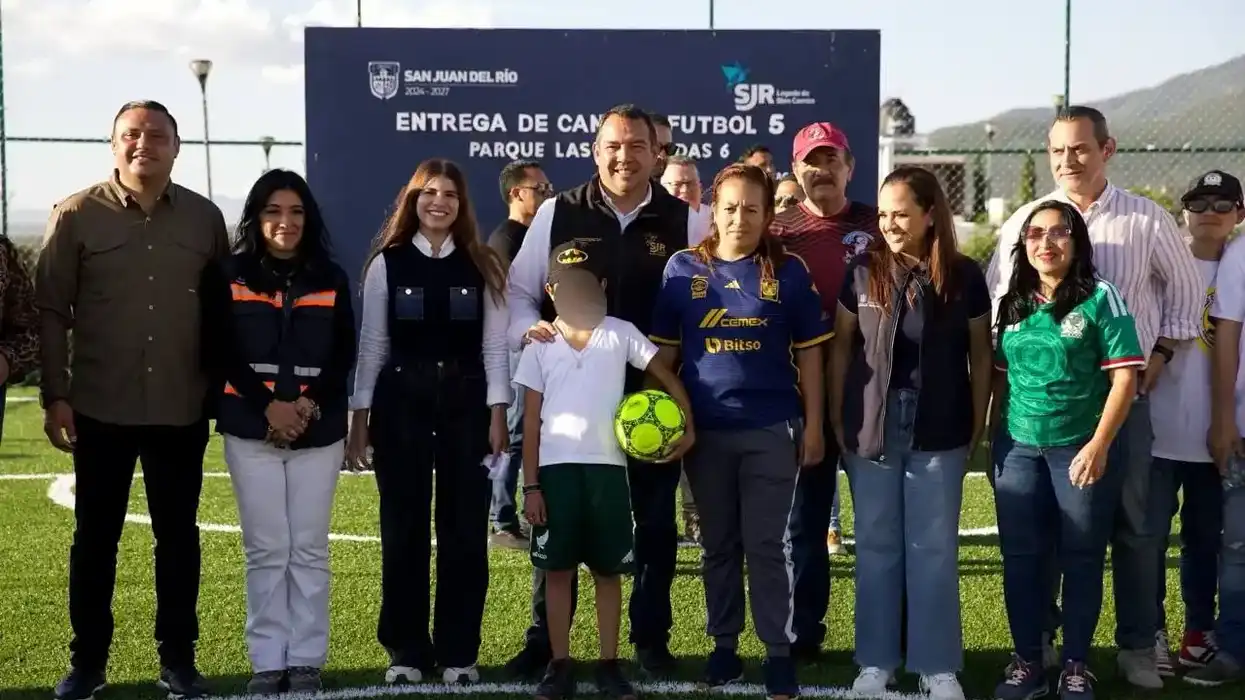 Autoridades municipales y colonos posan ante el cartel de entrega de la cancha de fútbol 5 en Parque Las Haciendas 6