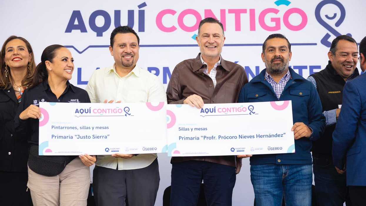 Autoridades y docentes sostienen vales de entrega para preescolares y primarias de San Juan del Río durante la ceremonia