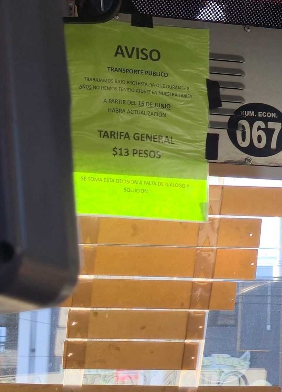 Aviso pegado en el parabrisas de una unidad del transporte p\u00fablico de San Juan del R\u00edo que advierte tarifa general de 13 pesos.