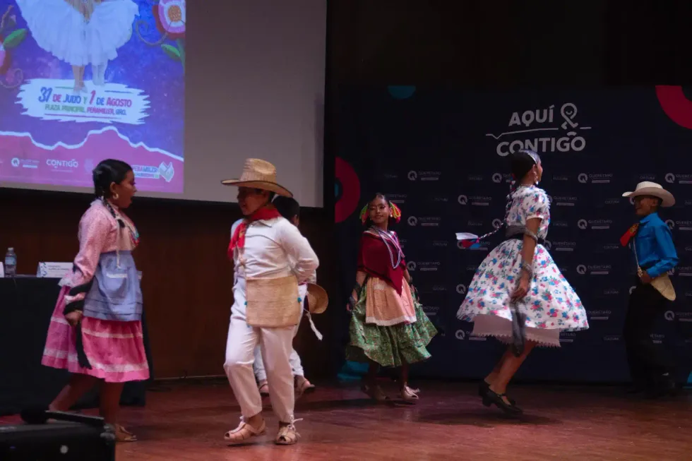 Bailarinas y bailarines infantiles con trajes tradicionales huastecos sobre el escenario