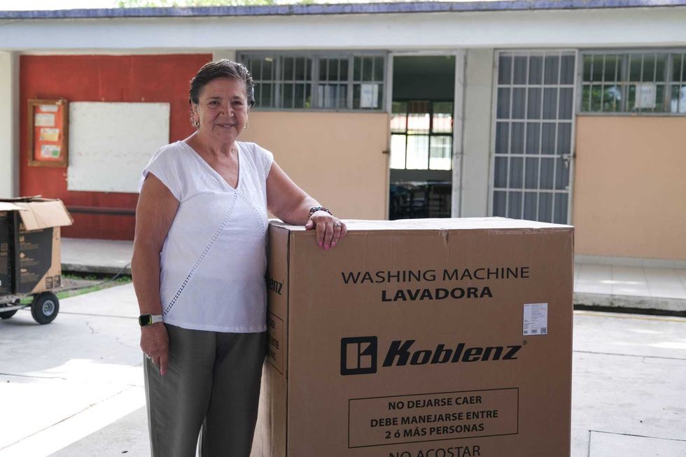 Beneficiaria posa junto a una lavadora entregada por el Programa de Coinversi\u00f3n Social en San Rafael, Corregidora
