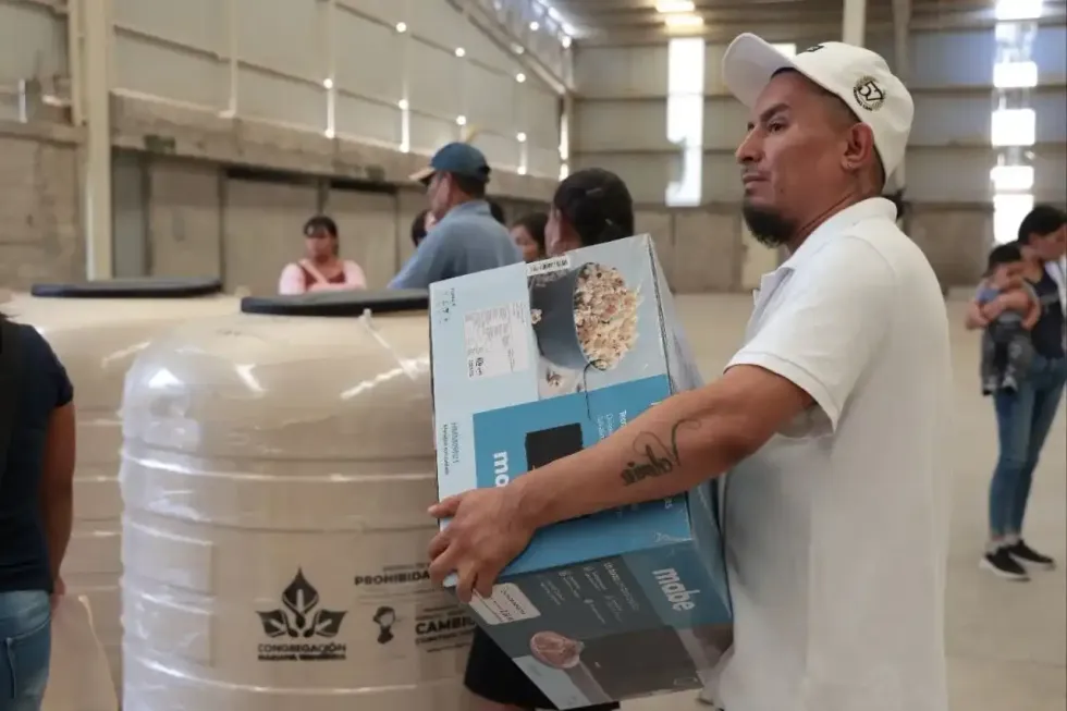 Beneficiario traslada caja de estufa afuera de bodega en Pe\u00f1amiller