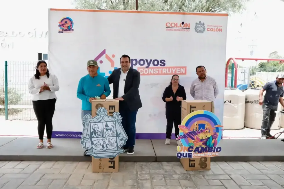 Beneficiario y autoridades municipales posan junto a cajas de colchones entregados en Col\u00f3n.