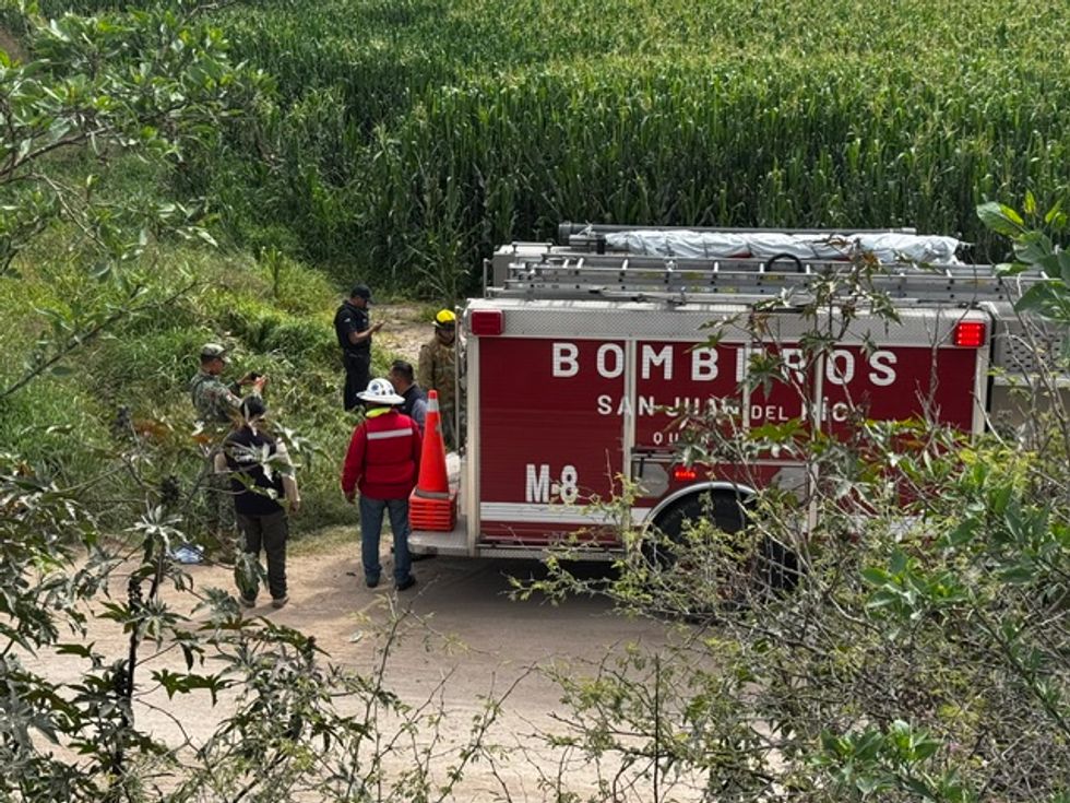 Bomberos y personal de Protecci\u00f3n Civil se re\u00fanen junto a un cami\u00f3n contraincendios al borde de la milpa en Santa Matilde