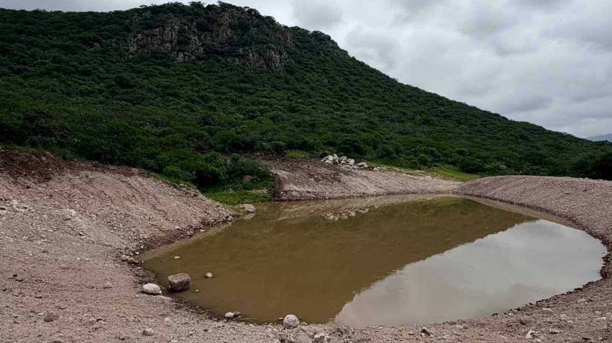 Bordo de regulación con agua acumulada al pie de un cerro, en el ejido Cerro Gordo, San Juan del Río, Querétaro