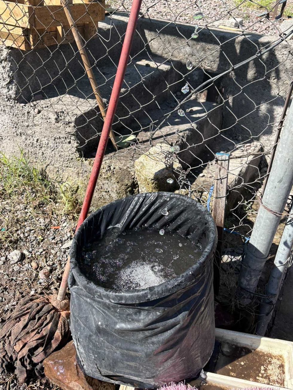 Bote cubierto con pl\u00e1stico negro se llena con agua que gotea a trav\u00e9s de una malla cicl\u00f3nica en avenida R\u00edo Moctezuma, San Juan del R\u00edo.