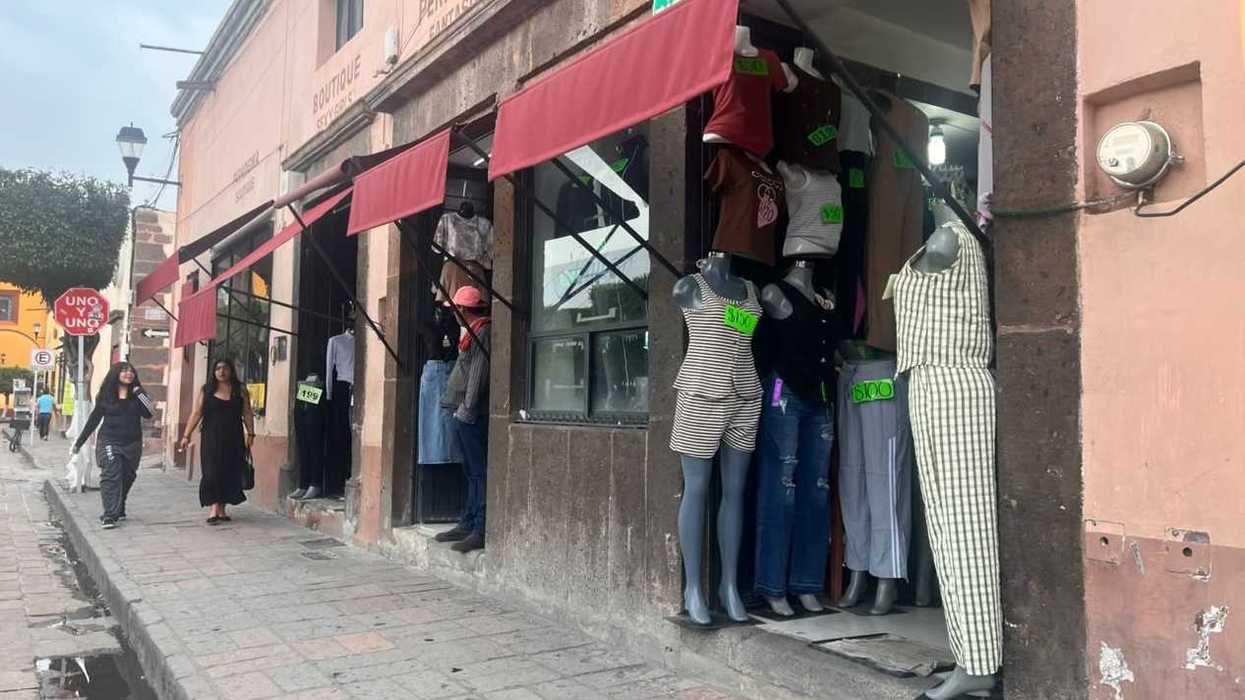 Boutiques de ropa con maniquíes y precios en una calle comercial del centro de San Juan del Río