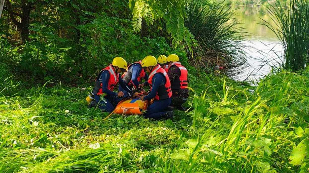Brigadistas con helmets amarillos practican rescate acuático en cuerpo de agua durante curso de Conagua en Querétaro