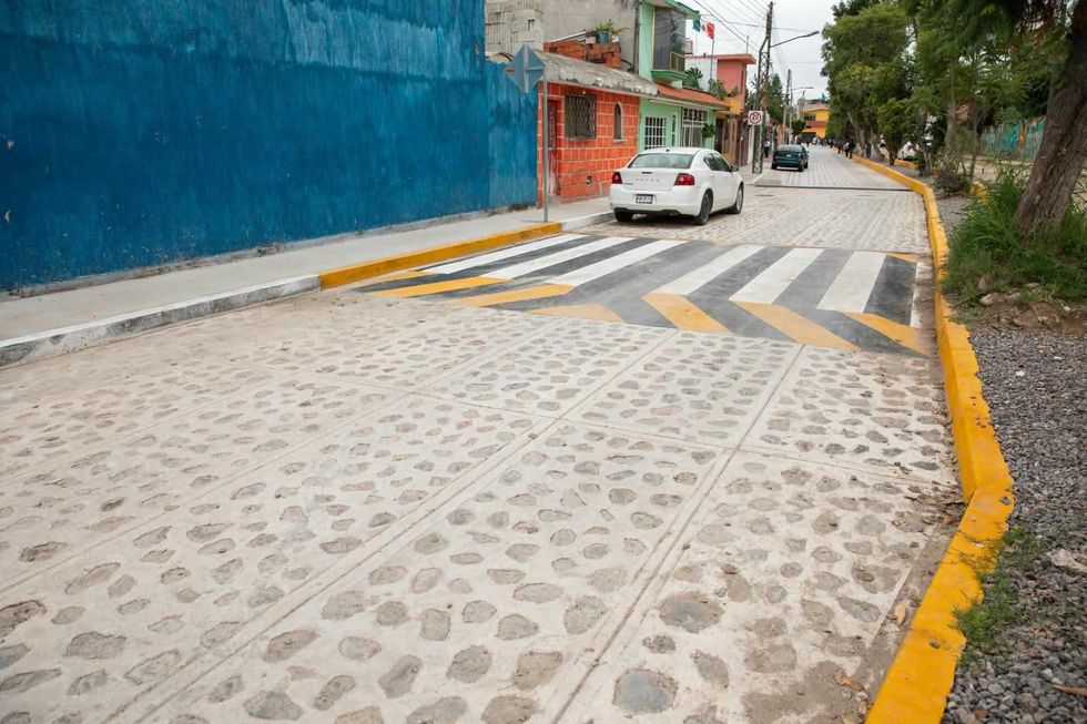 Calle con empedrado en mortero y guarniciones amarillas en la colonia Infonavit San Isidro, San Juan del R\u00edo