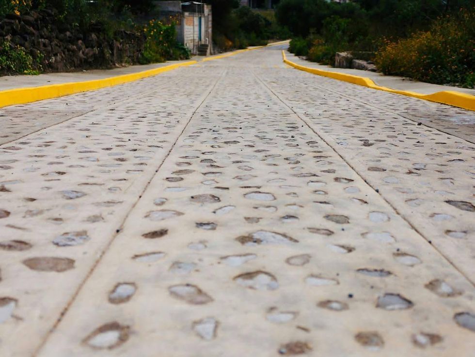 Calle Miguel Hidalgo en Santa B\u00e1rbara La Cueva con pozo de visita al centro del empedrado h\u00famedo