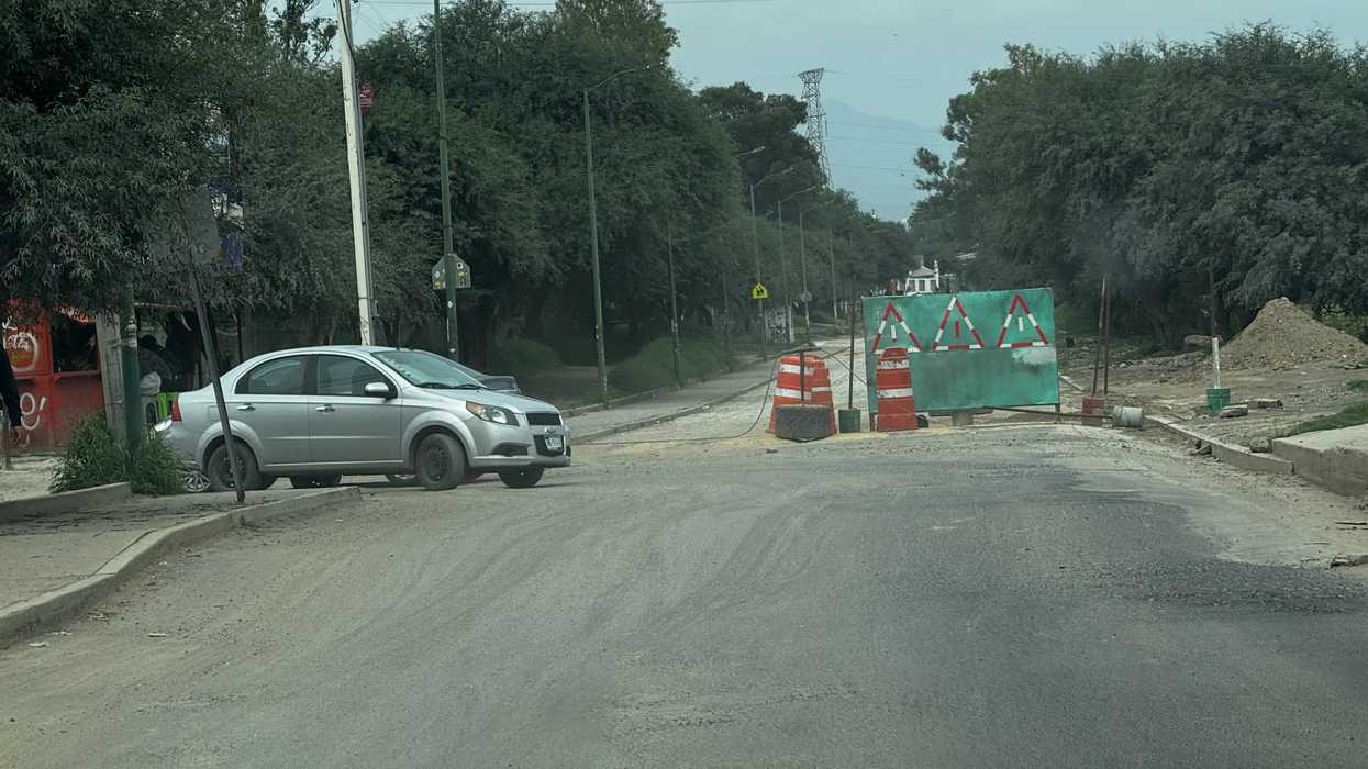 Camino de terracería hacia La Estancia bloqueado con conos y señal preventiva por obra