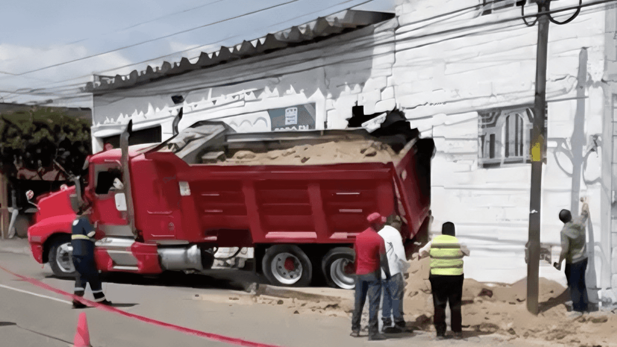 Camión materialista rojo cargado con tepetate impactado contra una ferretería en avenida México.