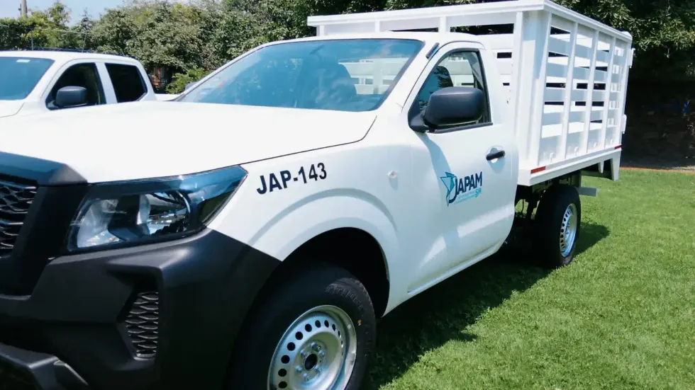 Camioneta blanca tipo estaca con logotipo de JAPAM y n\u00famero econ\u00f3mico JAP-143