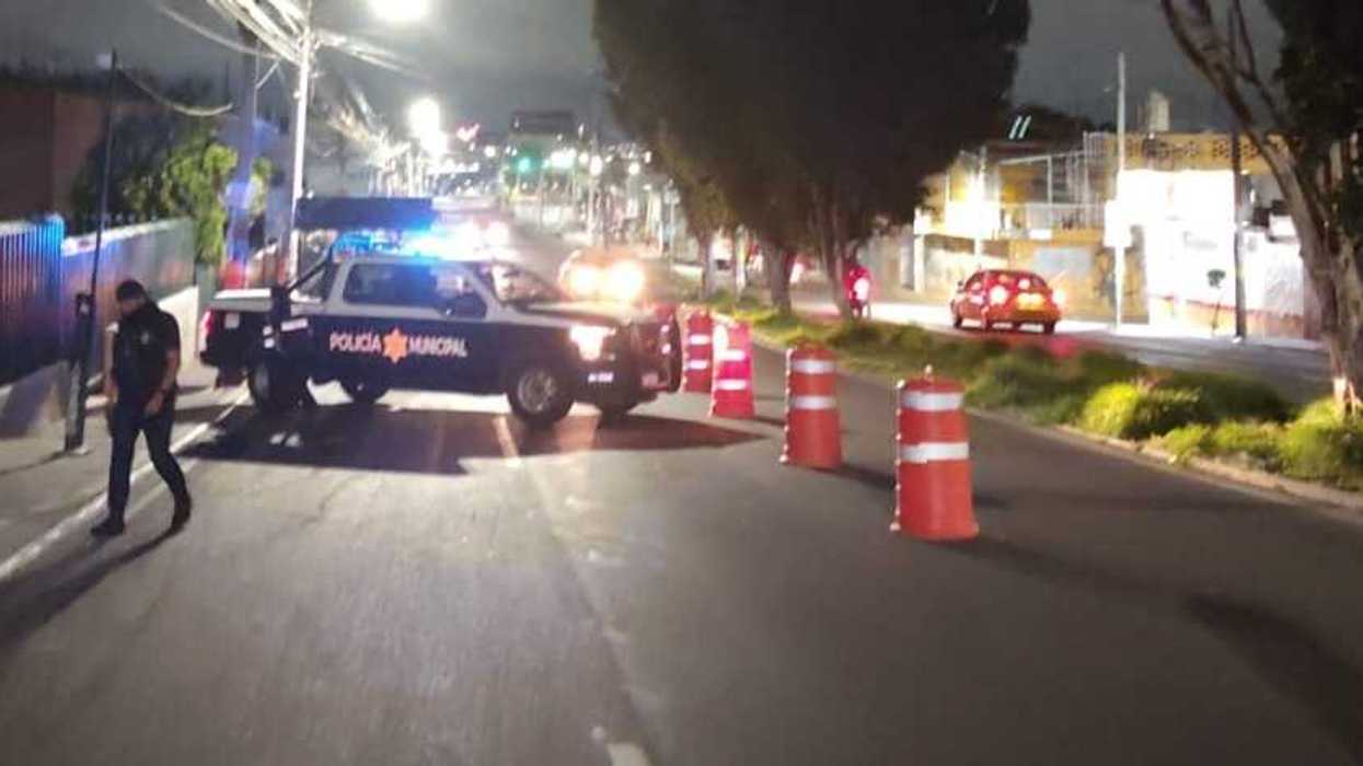 Camioneta de la Policía Municipal con torretas encendidas atravesada en un carril junto a conos naranjas durante el operativo alcoholímetro nocturno en Querétaro.