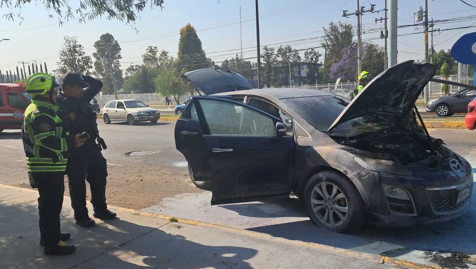Camioneta Mazda gris incendiada sobre Avenida Tecnol\u00f3gico en San Juan del R\u00edo, con presencia de bomberos en el lugar