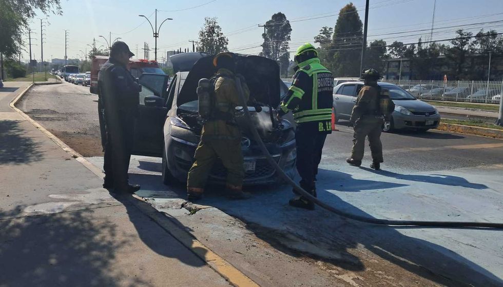 Camioneta Mazda gris incendiada sobre Avenida Tecnol\u00f3gico en San Juan del R\u00edo, con presencia de bomberos en el lugar